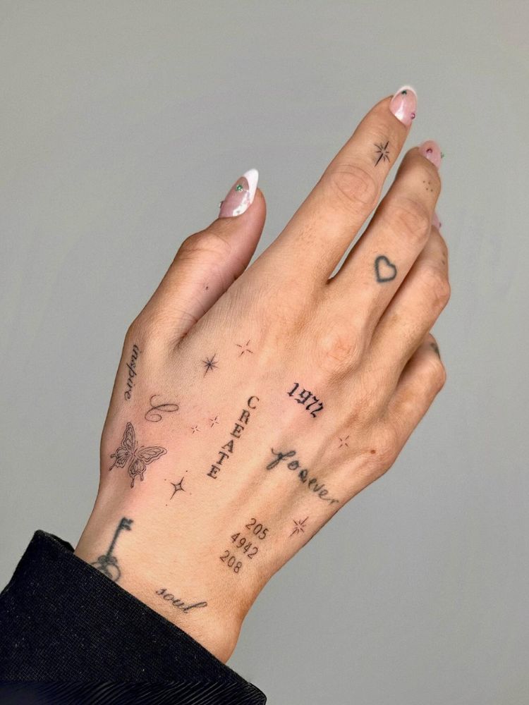 Mão de pele clara com várias pequenas tatuagens em fineline