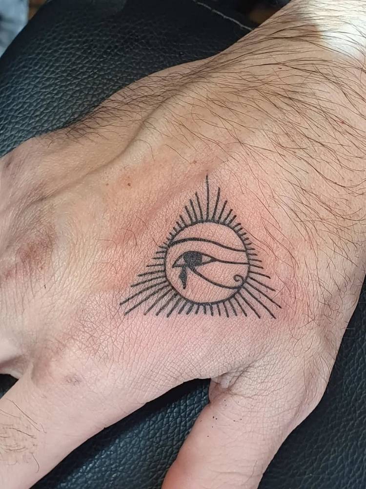 Mão com tatuagem pequena de Olho de Hórus