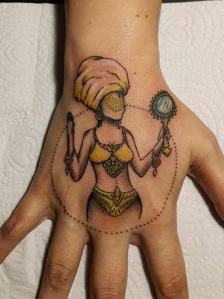 Mão tatuada em colorido com Oxum