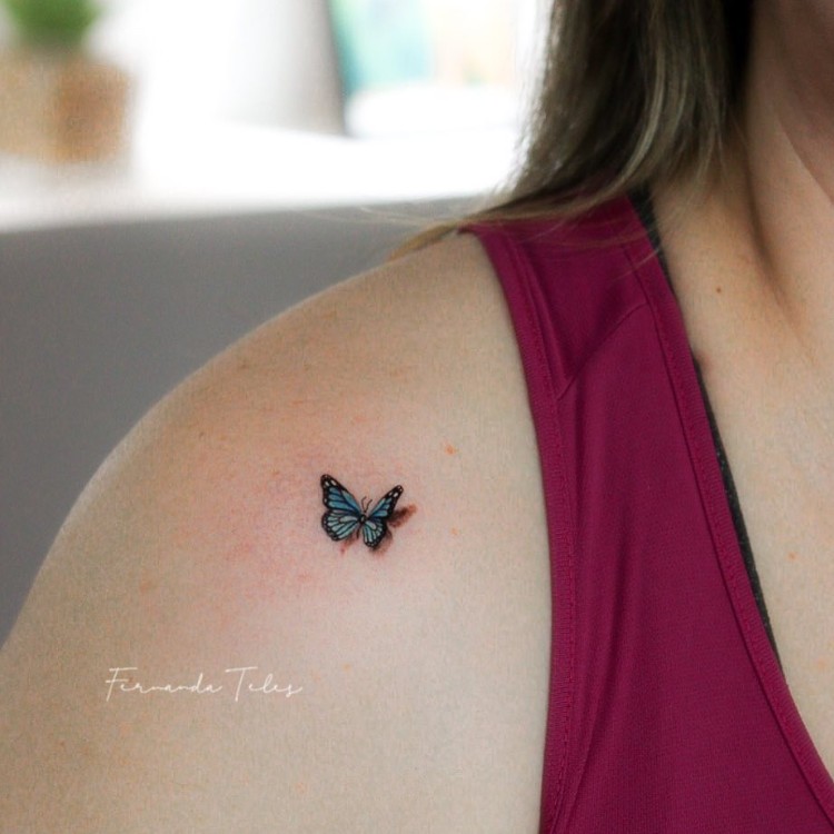 Tatuagem pequena de borboleta azul com sombra em ombro