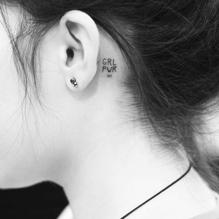tatuagens-pequenas-20 Foto em preto e branco de tatuagem pequena "GRL PWR" atrás da orelha, em fineline