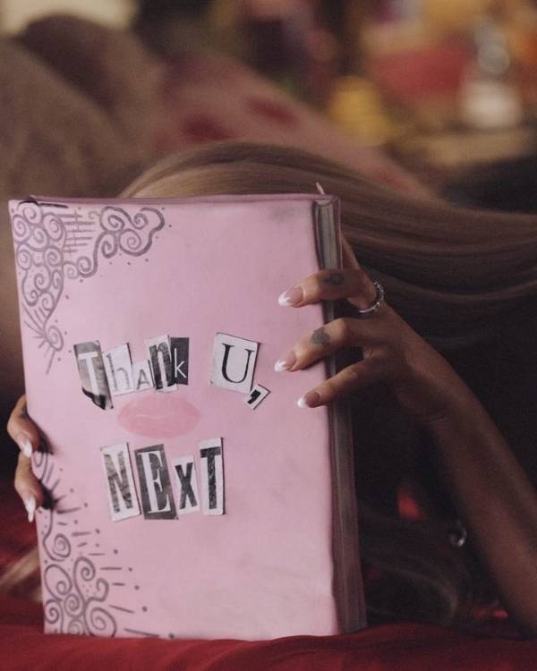Foto de livro Thank U, next, segurado por Ariana Grande.